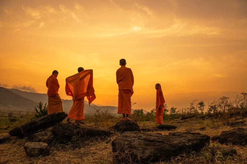 Buddhists monks watch sunset along Thailand border